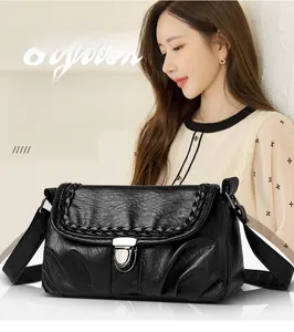 Détail du sac carré vintage noir avec similicuir brillant et fermoir en métal argenté