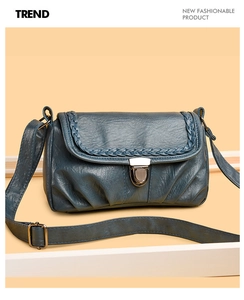 Détail du sac bandoulière bleu-gris avec bordure tressée et fermeture à boucle métal