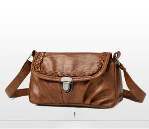 Détail du sac bandoulière vintage marron avec rabat tressé et boucle en métal argenté