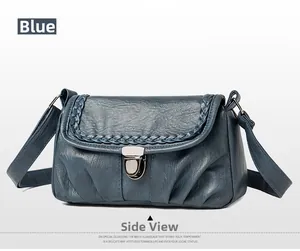 Détail du sac bandoulière bleu en similicuir avec bord tressé et fermoir métal