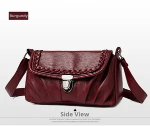 Gros plan du sac vintage bordeaux avec bordures tressées et boucle en métal argenté
