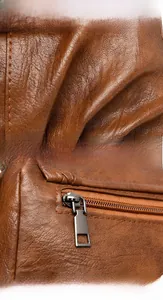 Détails macro du cuir marron texturé et du zip métallique de qualité sur un sac carré