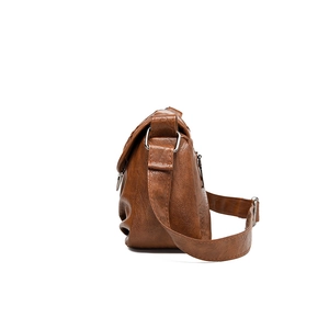 Sac bandoulière vintage marron pour femme avec sangle réglable sur fond blanc pur