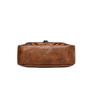 Vue du dessous d'un sac bandoulière vintage en cuir marron avec des coutures soignées