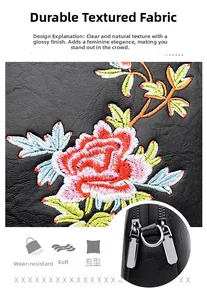 Macro detail of floral embroidery on soft black pebbled leather with silver double zippers