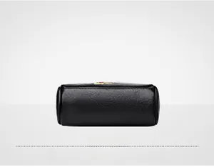 Detail view showing the flat bottom and textured black leather material of the embroidered bag
