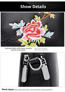 Detail of floral embroidery on soft black leather bag with double silver zippers