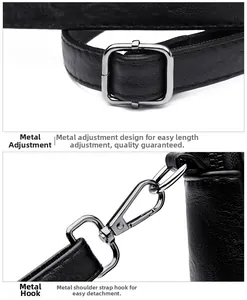 Detail of silver square buckle and lobster clasp on black textured leather bag strap