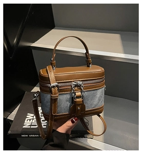 Detail of color-block box bag with brown leather and blue denim patchwork design
