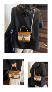 Detail of a retro color-block barrel bag with canvas拼接 and metal chain accents