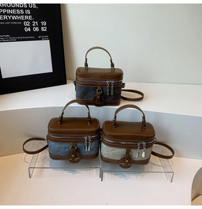 Three retro crossbody bags in grey, blue, and beige with leather trim and dual zippers
