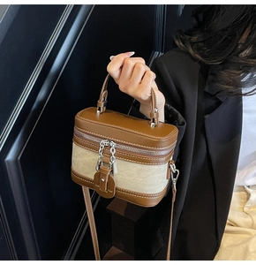 Detail of vintage box bag featuring brown leather trim and beige canvas fabric texture