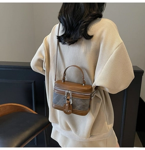 Detail of vintage brown leather patchwork crossbody bag with metallic zipper and charm