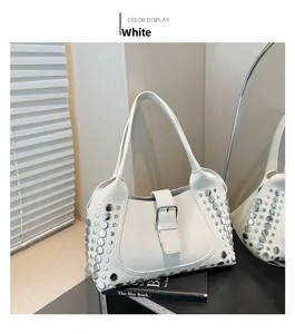 Dettaglio ravvicinato della borsa bianca in pelle con rivetti metallici argento