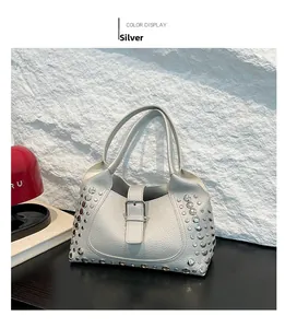 Dettaglio borsa a mano argento in pelle martellata con borchie metalliche e fibbia