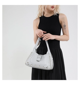 Dettaglio della borsa a secchiello argento con borchie metalliche e pelle litchi