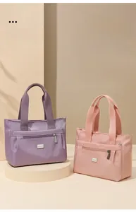 Dettaglio delle borse tote in nylon viola e rosa con zip metalliche e finitura satin