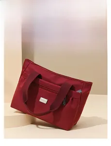 Vista dettagliata della borsa tote in nylon bordeaux con cerniera e placca logo in metallo