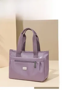 Dettaglio borsa tote in nylon lavanda con tasca a zip e placchetta logo argentata