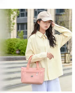 Borsa a spalla in nylon rosa con tasca zip e dettaglio logo in metallo all'aperto