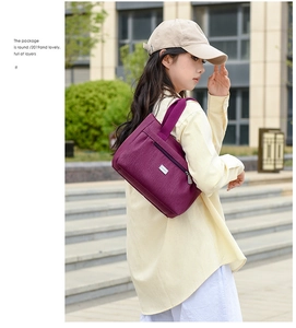 Dettaglio della borsa tote in nylon bordeaux con logo in metallo e tasca laterale zip