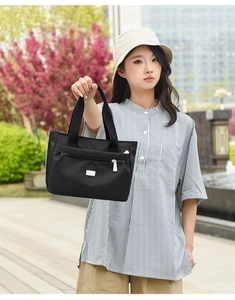 Dettaglio borsa a tracolla in nylon nero impermeabile con zip argento e logo metallico