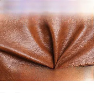 Detail of brown leather tote showing soft texture, oily grain, and scratch-resistant finish