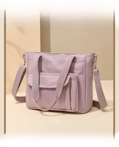 Close-up of pink nylon shoulder bag with adjustable strap and functional compartments