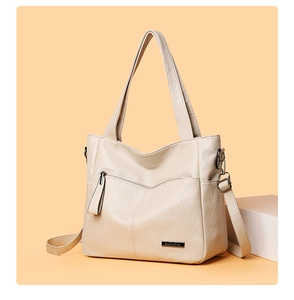 Close-up of beige vintage wrinkled PU leather tote bag with silver hardware detail