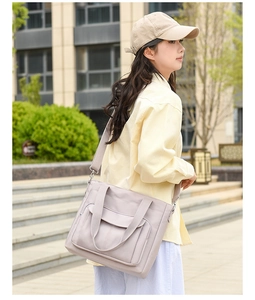 Close-up of lilac nylon shoulder bag with front flap pocket on outdoor steps