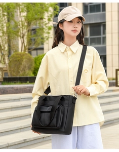Detailed view of black nylon shoulder bag with adjustable strap and silver hardware