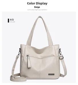 Detail of off-white faux leather tote bag showing vertical stitching and metal logo