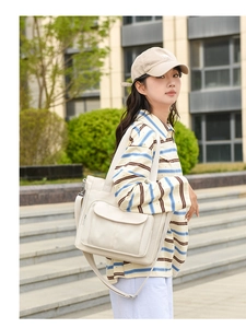 Outdoor lifestyle view of a large white nylon tote bag with adjustable shoulder straps