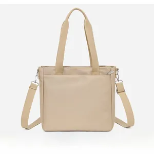 Detail view of the back pocket on a beige nylon tote bag with high-quality zipper