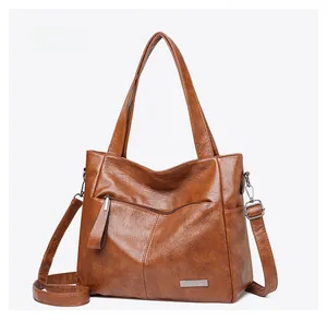 Macro shot of dark brown tote bag showing textured PU leather and silver metal zipper detail