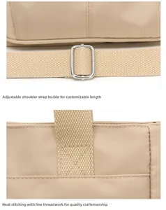 Macro detail of the silver metal buckle and reinforced stitching on the nylon shoulder bag