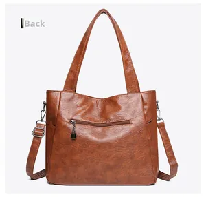Rear view of brown vintage leather tote bag showing hidden zipper pocket and strap hooks