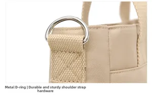Detailed macro of durable silver D-ring hardware on beige nylon shoulder bag