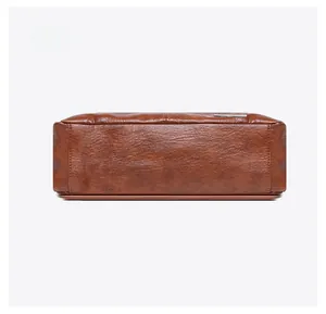 Detail view of the bag bottom showing premium lychee grain leather and neat stitching