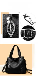 Detail der schwarzen Leder-Tote-Bag mit Blatt-Anhänger und silbernen Metallschnallen