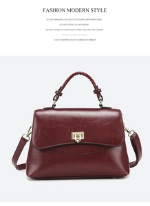 Detailed close-up of wine red faux leather bag with gold metal buckle and top handle