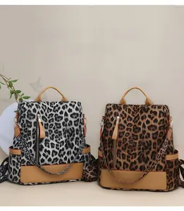 Vue détaillée de sacs à dos à imprimé léopard gris et marron avec finitions en cuir