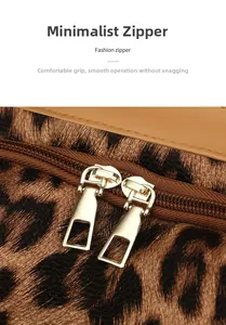Détail des doubles fermetures éclair dorées et du tissu léopard sur le sac à dos tendance
