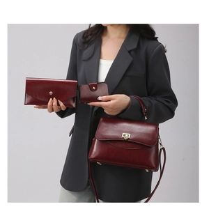 Three-piece set of wine red vintage leather handbags including purse and card holder
