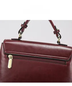 Detailed view of burgundy leather handbag with premium gold zipper and precise stitching