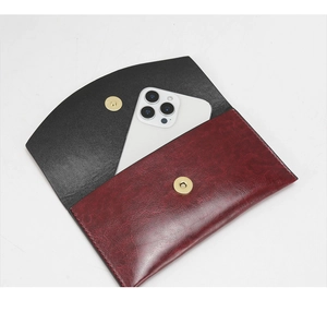 Detail of color-block burgundy wallet with magnetic snap closure and smartphone size reference