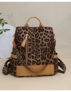 Détail d'un sac à dos imprimé léopard avec fermeture dorée et garniture en cuir