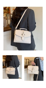 Detail showing versatile crossbody and handbag carry styles of the cream square leather bag