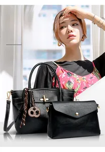 Detail of black leather tote and envelope crossbody bag set with woven tassel and metal hardware