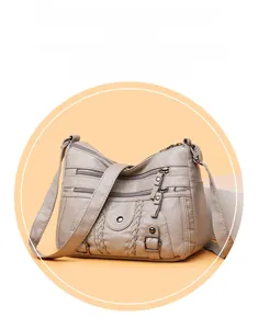 Détail d'un sac bandoulière beige en cuir lavé avec tresses décoratives et multi-poches